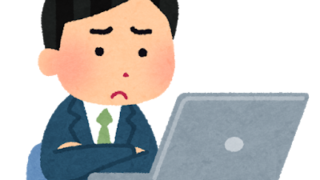 パソコンを見つめながら悩む男性