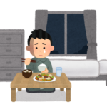 一人暮らしでさびしく食事をする男性