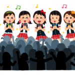 観客の前で歌う女性アイドルグループ
