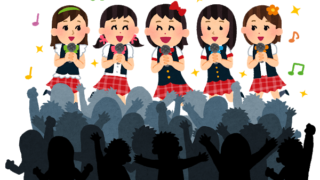 観客の前で歌う女性アイドルグループ