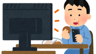 ながらスマホで一人でテレビを観ている男性